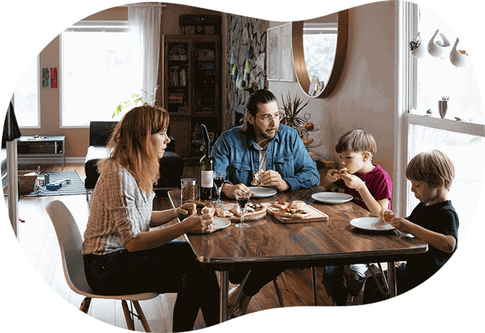 Une famille avec deux enfants mange ensemble à table